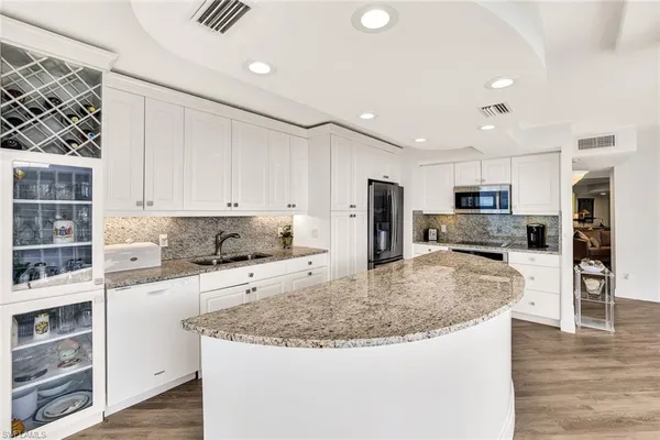 a kitchen with stainless steel appliances granite countertop a sink refrigerator and cabinets