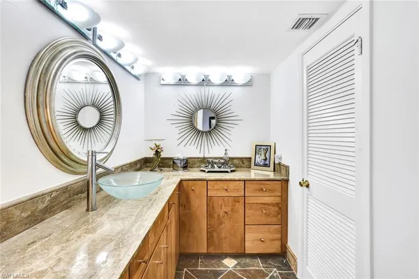 a kitchen with a sink a cabinets and chairs