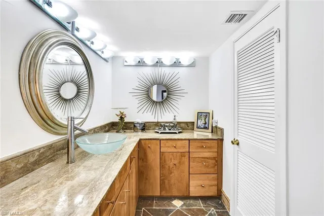 a kitchen with a sink a cabinets and chairs