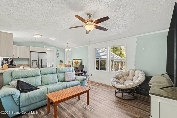 a living room with furniture a table and a large window