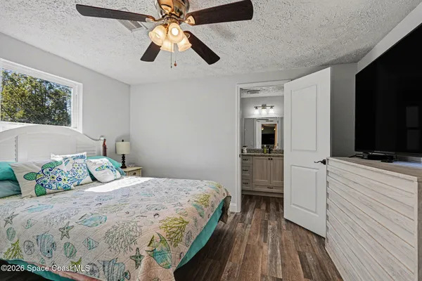 a bedroom with a bed and a flat tv screen on dresser