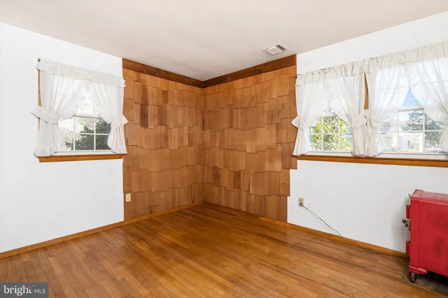 a view of a room with wooden floor and a window