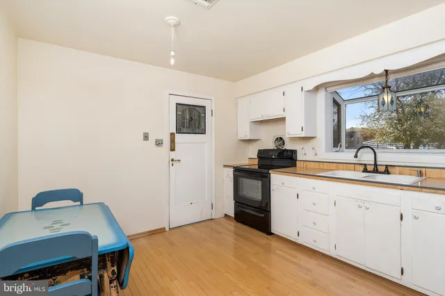 a kitchen with a sink cabinets and wooden floor