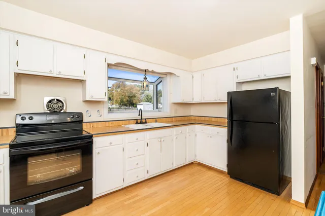 a kitchen with a refrigerator stove and white cabinets