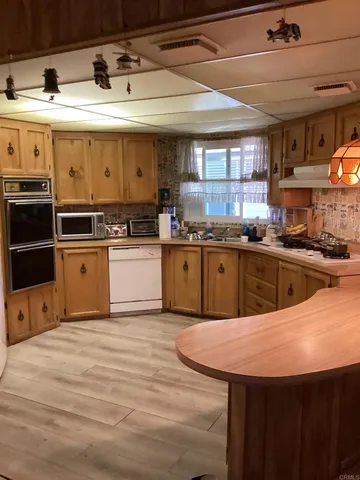 a kitchen with stainless steel appliances granite countertop a sink counter space and wooden floors
