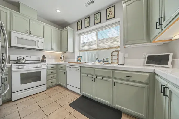 a kitchen with cabinets stainless steel appliances and a sink