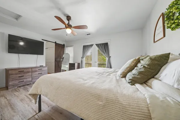 a bedroom with a large bed and a flat screen tv