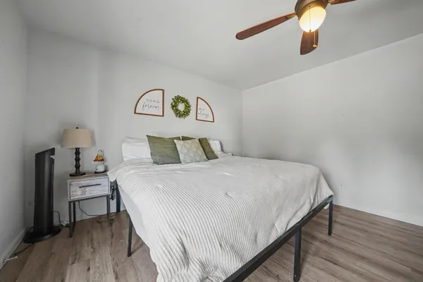 a bedroom with a bed and wooden floor