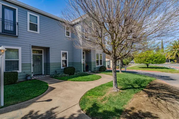 a view of a house with a yard and pathway