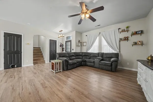 a living room with furniture and a wooden floor