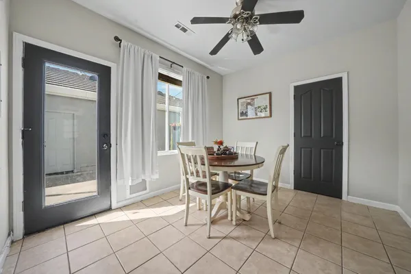 a view of a dining room with furniture and a chandelier fan