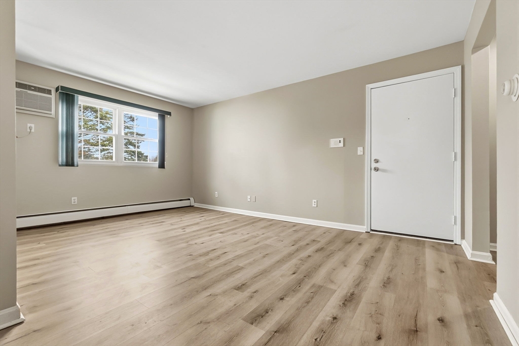 6 Venice Street, Unit B6 Danvers, MA 01923 - Photo 4 of 19 a view of an empty room with wooden floor and a window