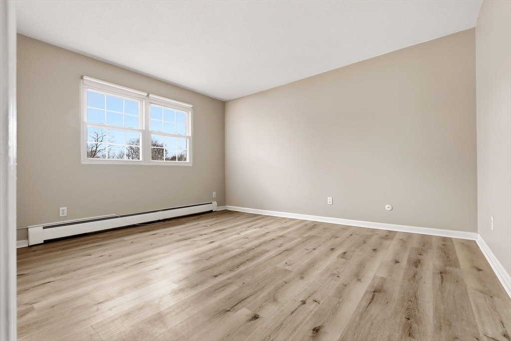 6 Venice Street, Unit B6 Danvers, MA 01923 - Photo 10 of 19 an empty room with wooden floor and windows