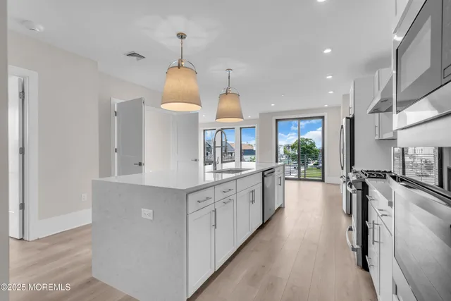a kitchen with counter top space a sink stainless steel appliances and cabinets