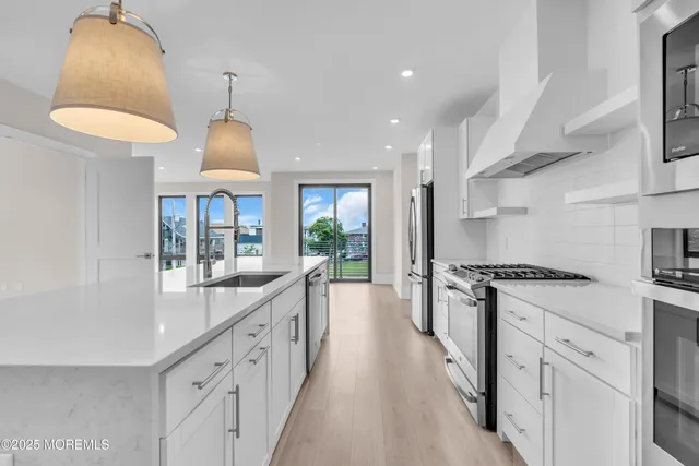 a large kitchen with stainless steel appliances granite countertop a lot of counter space and a sink