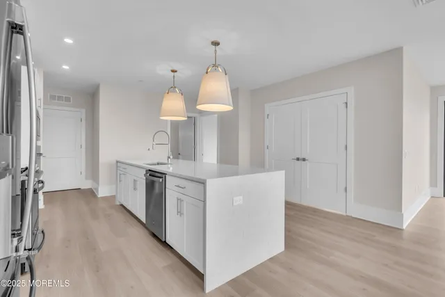 a kitchen with stainless steel appliances a stove top oven a sink and a refrigerator