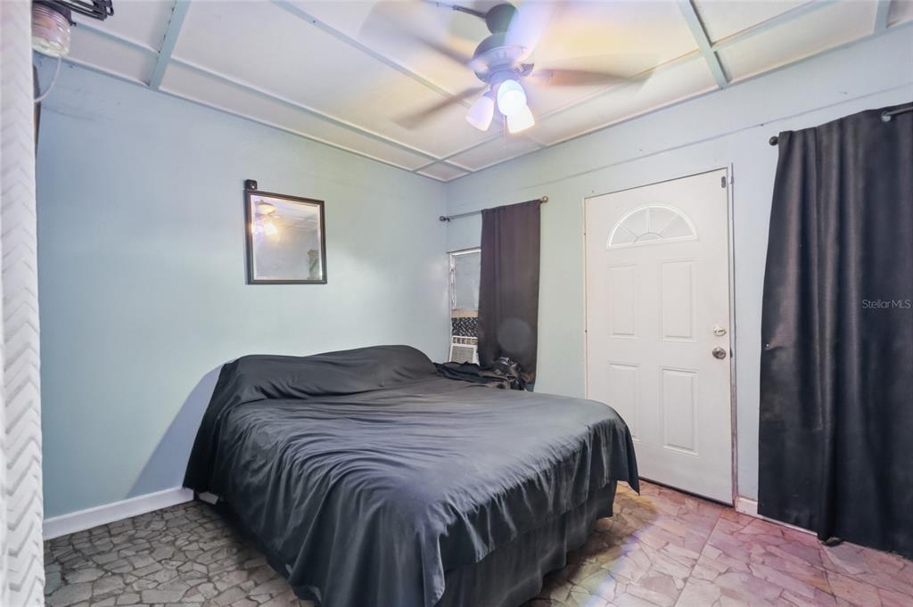 3027 Queens Gate Road Orlando, FL 32818 - Photo 32 of 34 a bedroom with a bed and a chandelier
