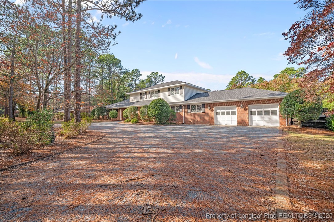 2000 Airport Road Whispering Pines, NC 28327 - Photo 4 of 50 a front view of a house with a garden and street view