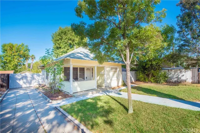 a view of a house with backyard and a tree