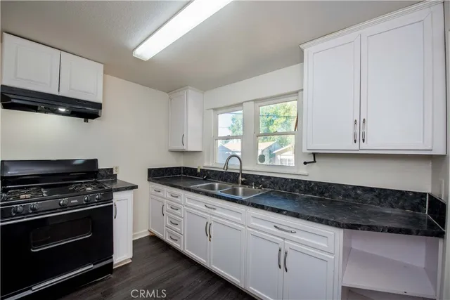 a kitchen with granite countertop a stove and a sink