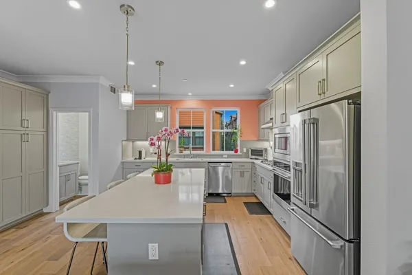 a kitchen with white cabinets and stainless steel appliances
