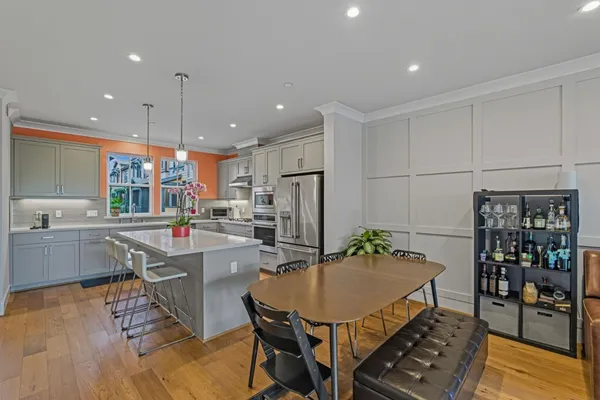 a kitchen with stainless steel appliances a dining table chairs and granite counter tops