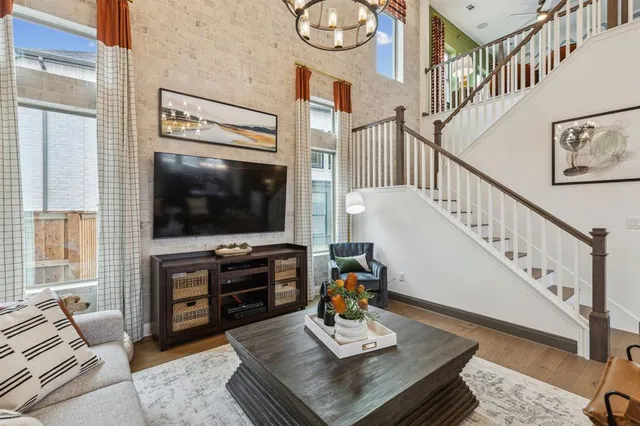 a living room with furniture a flat screen tv and a large window