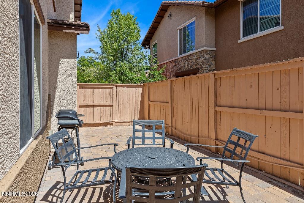 1864 Wind Ranch Road, Unit B Reno, NV 89521 - Photo 33 of 42 a view of a patio with table and chairs with wooden floor and fence