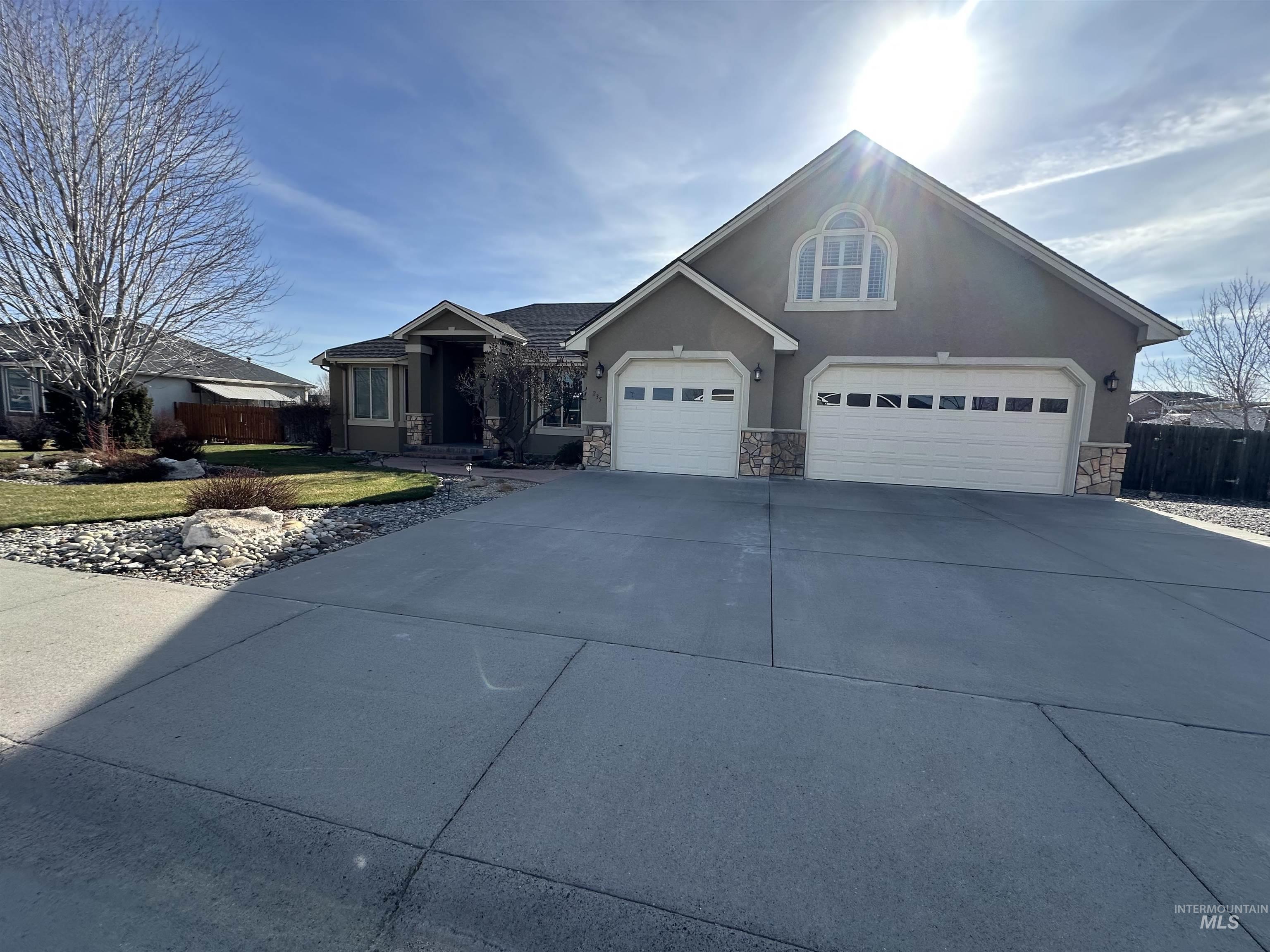 235 Northeast Greystone Loop Mountain Home, ID 83647 - Photo 2 of 5 View of front of home featuring stone siding, concrete driveway, stucco siding, and a garage