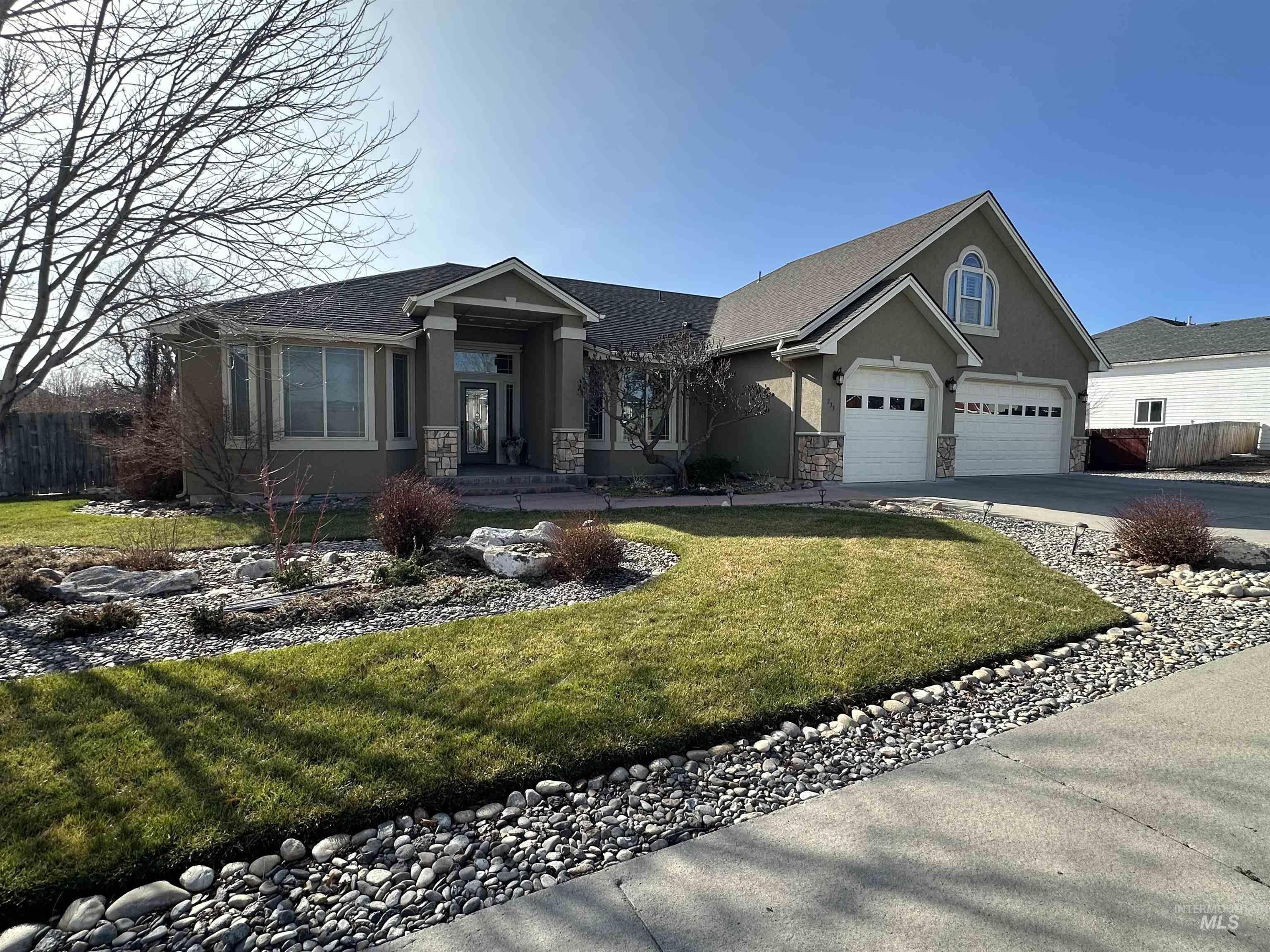 235 Northeast Greystone Loop Mountain Home, ID 83647 - Photo 5 of 5 View of front of property with stucco siding, stone siding, a garage, concrete driveway, and roof with shingles