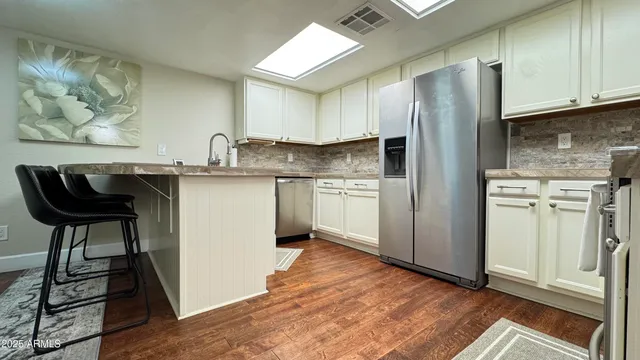 a kitchen with stainless steel appliances granite countertop a refrigerator and a stove top oven