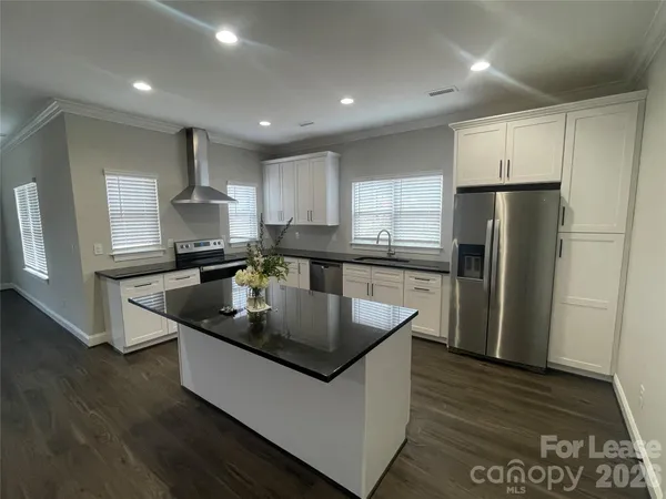 a kitchen with stainless steel appliances granite countertop a sink a refrigerator and a stove