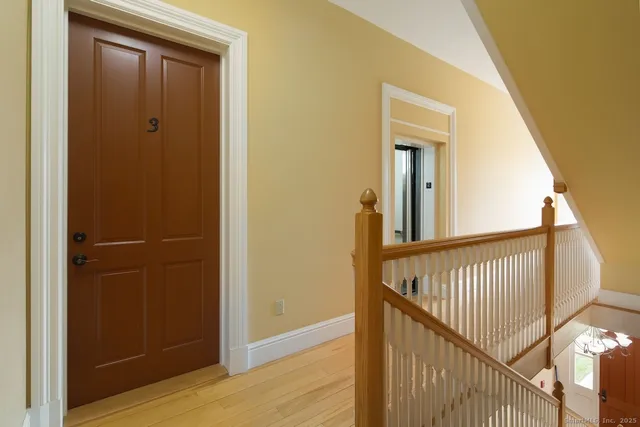a view of a hallway with wooden floor and entryway