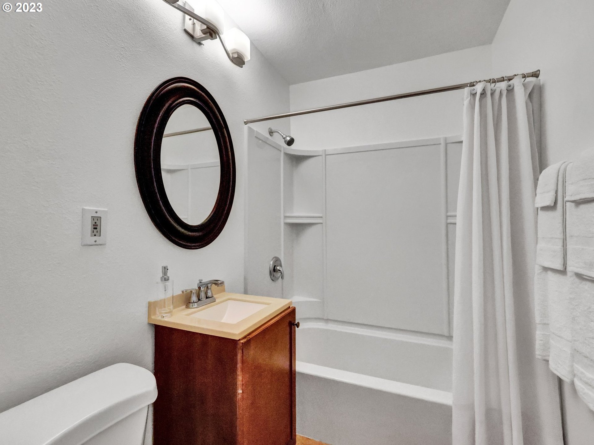 5606 Northeast 27th Avenue Portland, OR 97211 - Photo 17 of 48 a bathroom with a sink toilet a mirror and shower