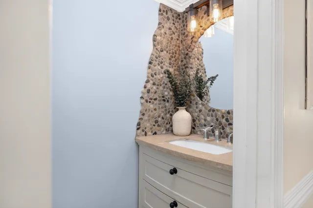 a bathroom with a granite countertop sink and shower curtain