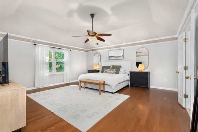 a bedroom with a bed and wooden floor