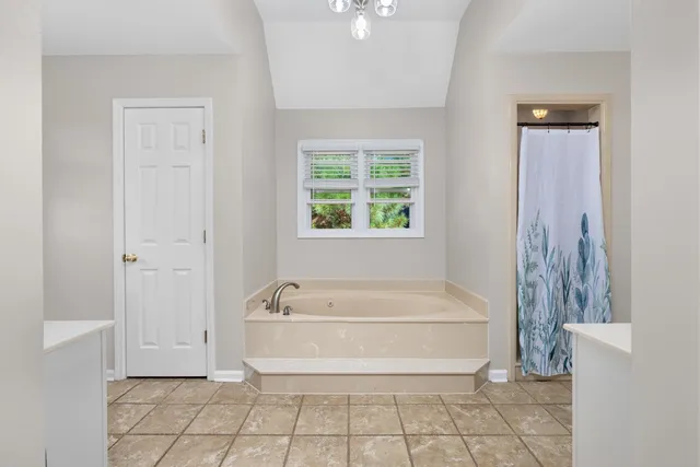 a spacious bathroom with a bathtub and next to a window