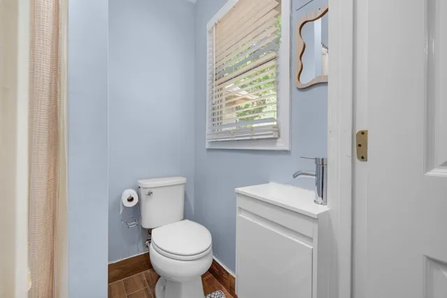 a bathroom with a toilet sink and mirror