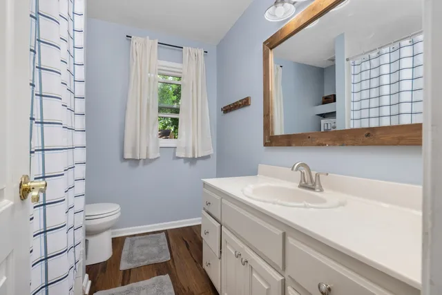 a bathroom with a sink a toilet and a mirror