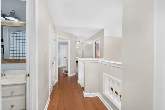 a view of a hallway with wooden floor and cabinet