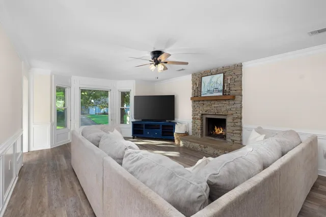 a living room with furniture a fireplace and a flat screen tv