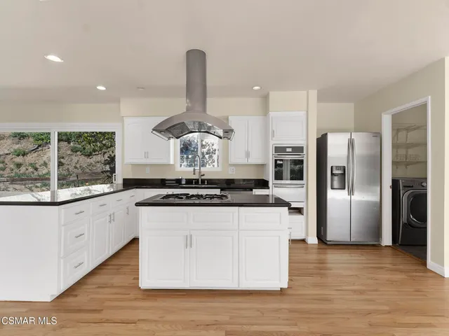 a view of kitchen with wooden floor and electronic appliances