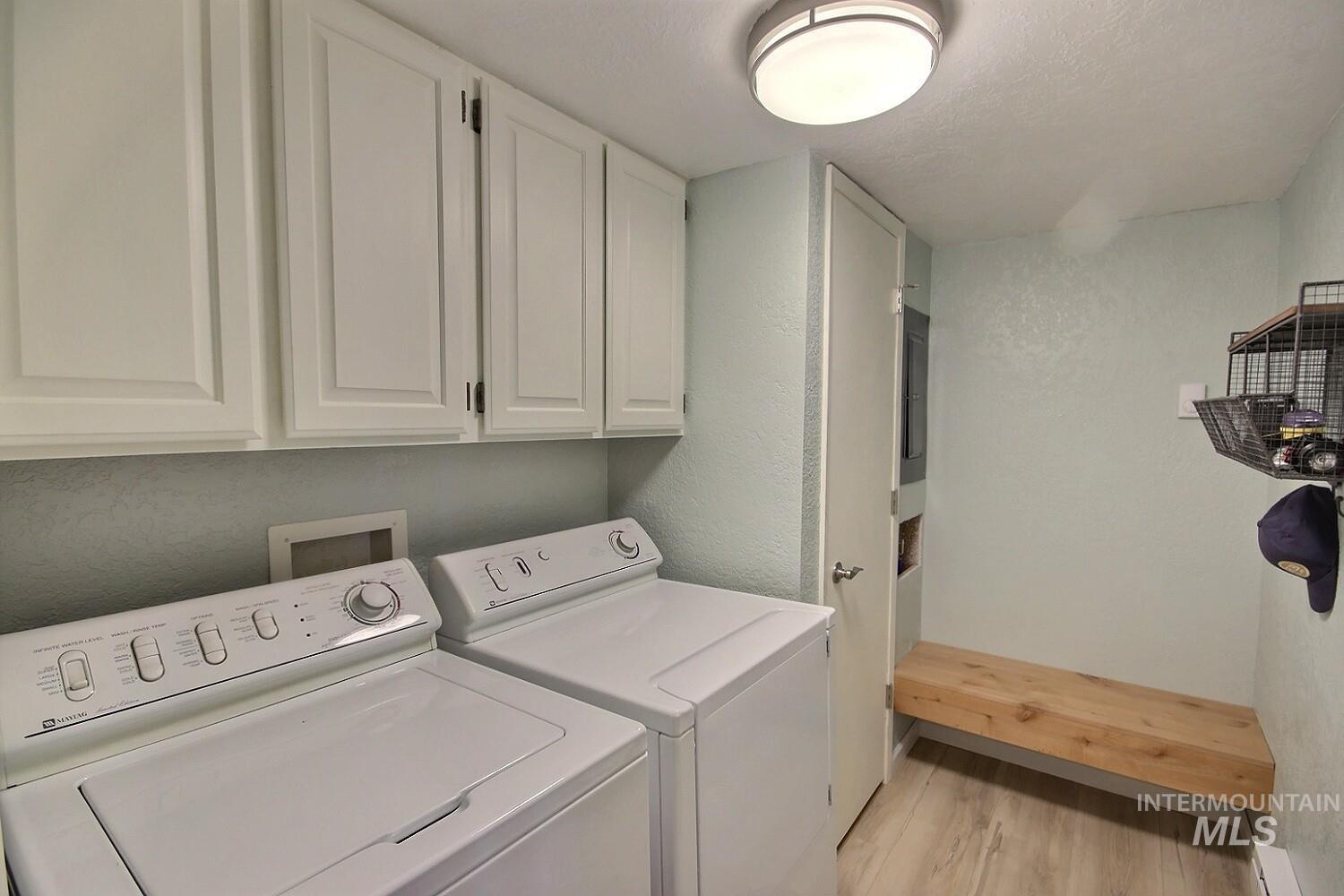 1640 Davis Avenue, Unit 7 McCall, ID 83638 - Photo 18 of 21 Laundry room with a textured wall, light wood finished floors, washer and clothes dryer, cabinet space, and a textured ceiling