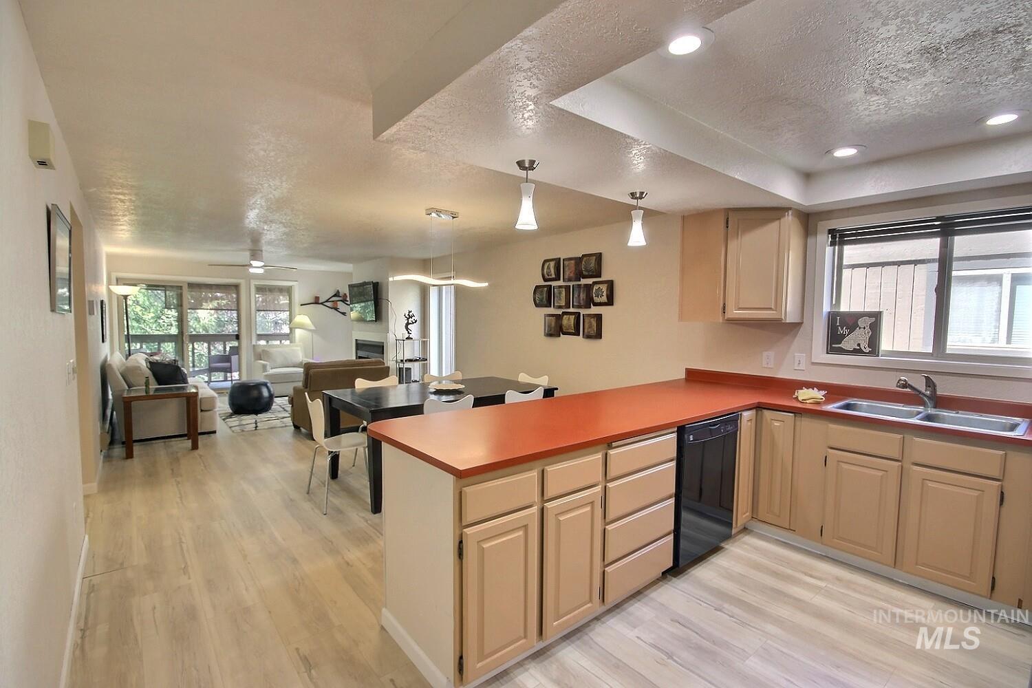 1640 Davis Avenue, Unit 7 McCall, ID 83638 - Photo 21 of 21 Kitchen featuring a textured ceiling, a peninsula, open floor plan, black dishwasher, and light wood-style flooring