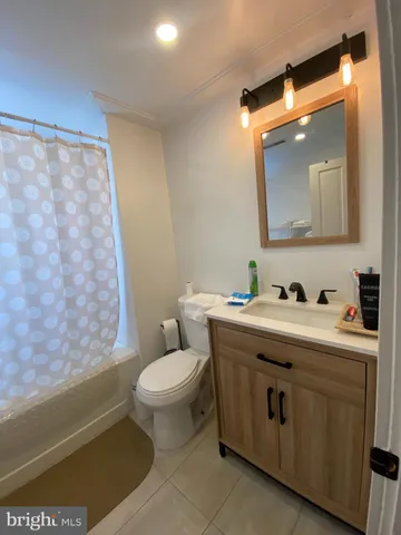 a bathroom with a granite countertop toilet sink and mirror