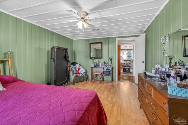 a bed room with a bed vanity and a mirror