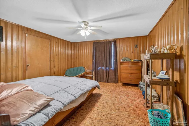 a bed sitting in a spacious bedroom next to a window