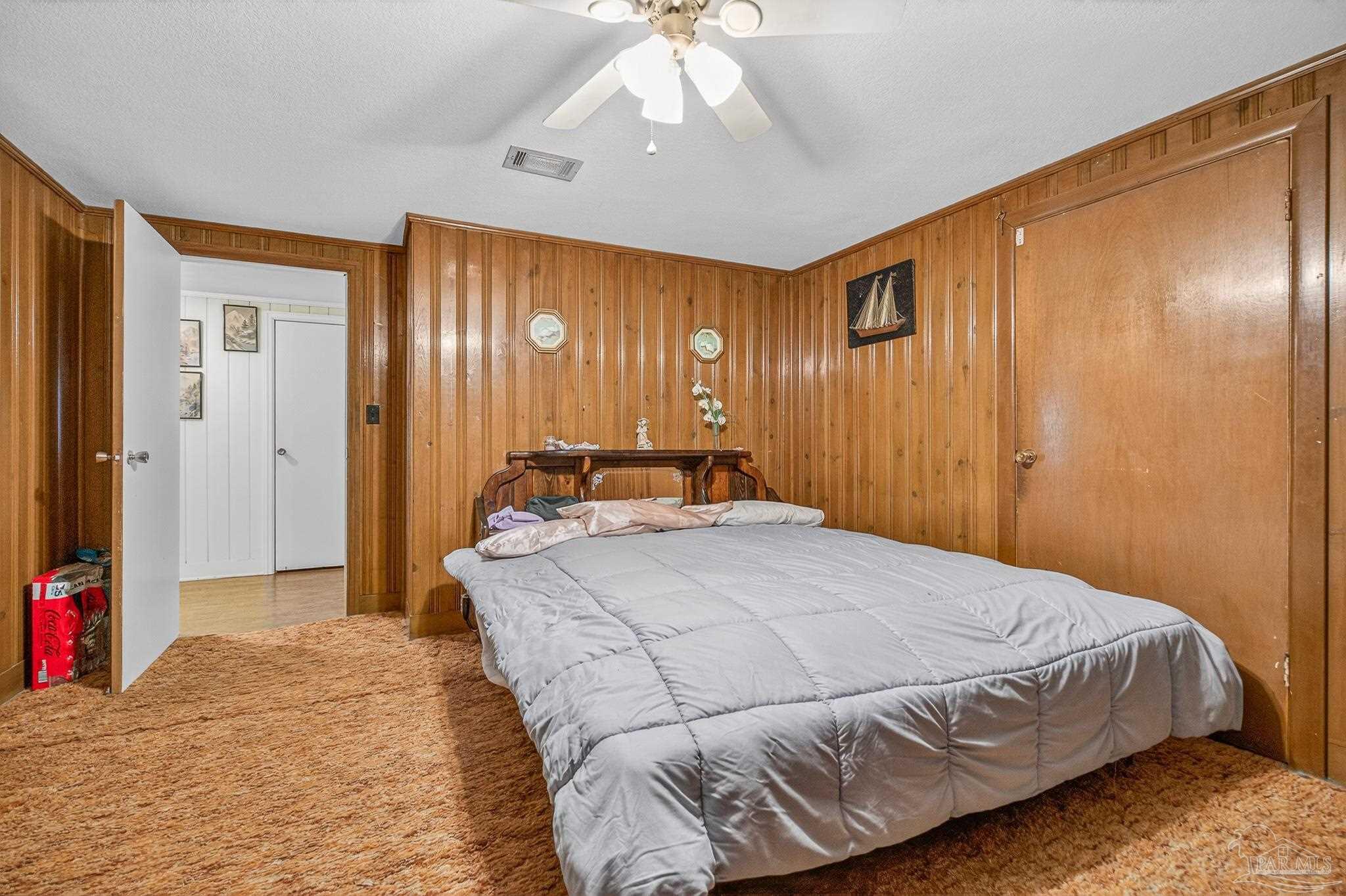 1450 East Burgess Road Pensacola, FL 32504 - Photo 18 of 49 a bedroom with a large bed and a chandelier