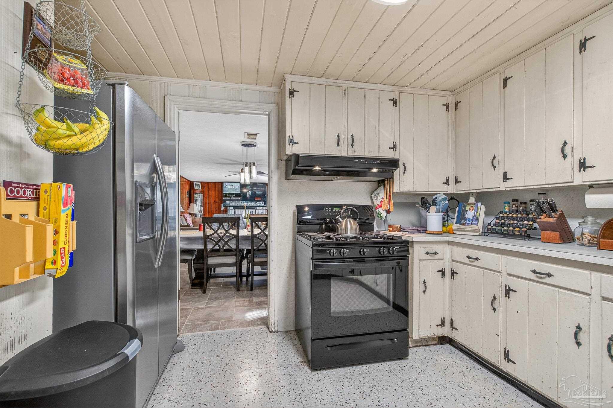 1450 East Burgess Road Pensacola, FL 32504 - Photo 28 of 49 a kitchen with stainless steel appliances granite countertop a refrigerator and a stove top oven
