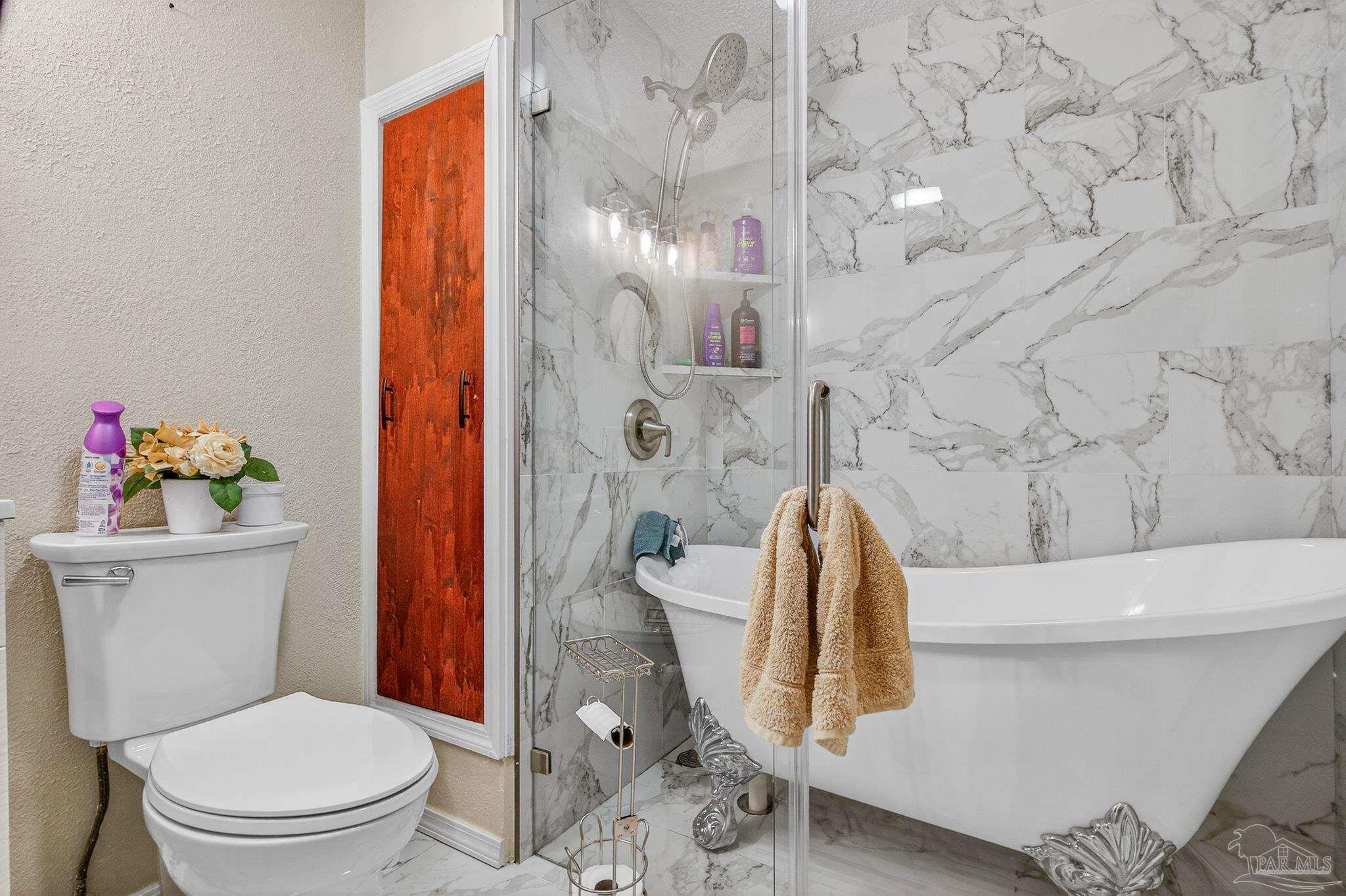 1450 East Burgess Road Pensacola, FL 32504 - Photo 7 of 49 a bathroom with a toilet and a shower curtain